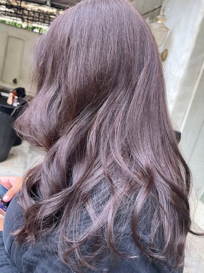 Another view of the mauve-brown hair color, showing how the light catches the subtle purple undertones. It's a great way to have a hint of color while still looking natural.