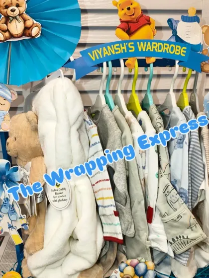 'Viyansh's Wardrobe' cart, neatly displaying a collection of baby clothes on hangers as part of the gift train.