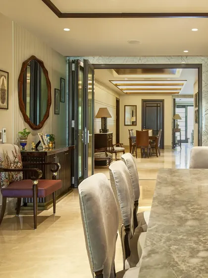 Another view showing the flow between spaces. The use of foldable doors and continuous marble flooring allows rooms to be either intimate or opened up into a larger, cohesive area.