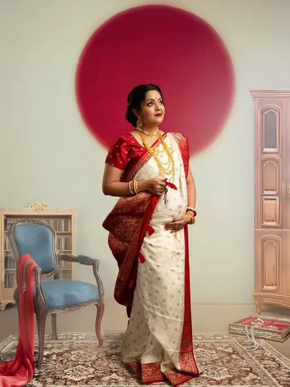 Celebrating Bengali heritage with a modern artistic touch. The prominent red bindi, or 'sindoor' mark, and the traditional white and red saree create a powerful and culturally significant portrait.