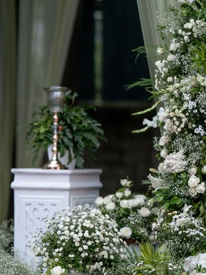 A close-up of the lush white floral arrangements flanking the entrance to the main ceremony area.