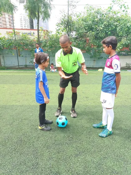 A referee gives instructions to our young U-7 captain before a match. These moments are important learning experiences for our future leaders.