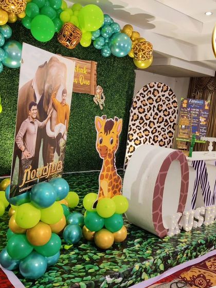 A side view of a jungle-themed first birthday, showing the arrangement of animal cutouts and balloon columns.