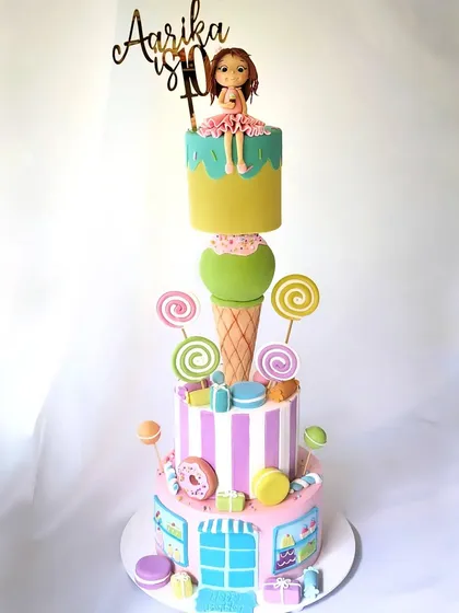 This four-tier anti-gravity candyland cake was a structural and artistic adventure. It features a giant ice cream cone that appears to balance the top tiers, surrounded by a cascade of lollipops, macarons, and donuts. It’s a whimsical creation that makes a huge statement at any party.
