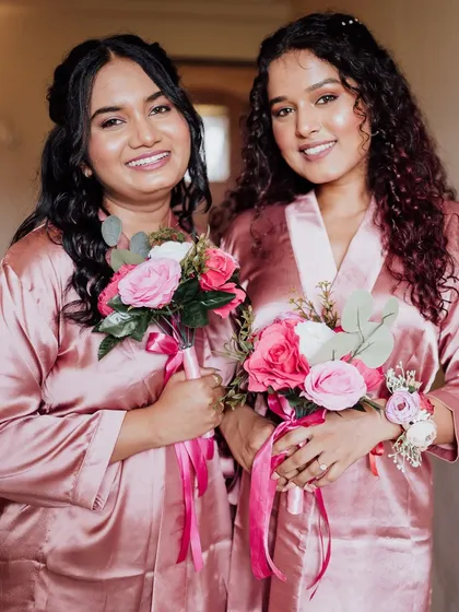 Another shot of the bridesmaids in their robes, holding their bouquets. Their makeup is fresh and radiant, perfect for the start of a wedding day.