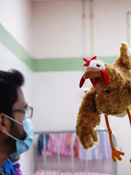 Paprika the chicken meets a healthcare worker. In these spaces, my puppets and I listen to the energy around us and create small bubbles of happiness wherever we can.
