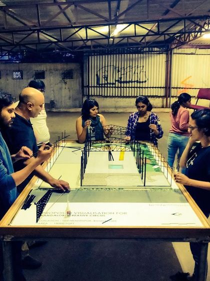 Our team gathered around a scale model of the space during the planning phase, visualizing the future of Bangalore Creative Circus.