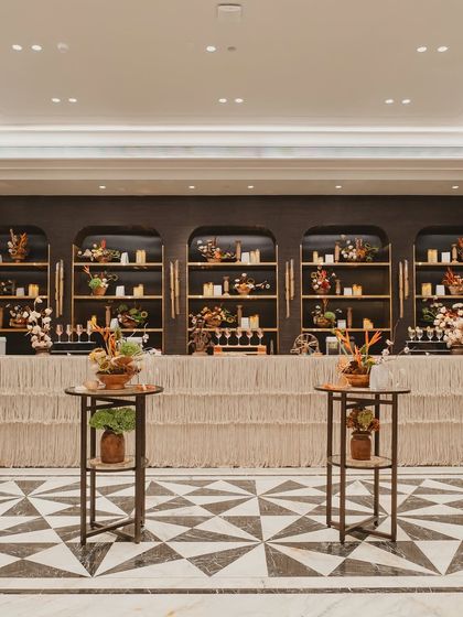 The bar design for the carnival event featured natural textures and a warm, candlelit back bar, blending seamlessly with the elegant and earthy decor.