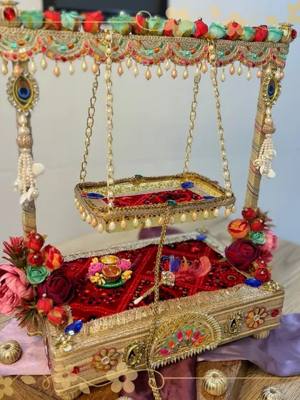 For Janmashtami, we lovingly handcraft these beautiful Krishna jhulas for Ladoo Gopal. This piece features a detailed swing, a rich red velvet base, and floral decorations, creating a divine seat for the lord's celebration.
