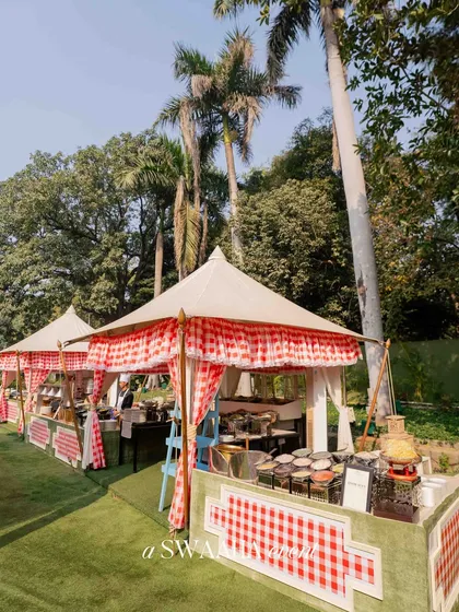 The food stalls for the baby shower, designed as cute, rustic tents with checkered awnings to perfectly match the countryside picnic theme.
