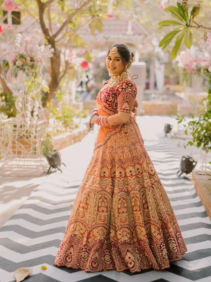 A beautiful full-length shot showing the bride's lehenga in all its glory. The classic updo and timeless makeup complete this elegant bridal look.