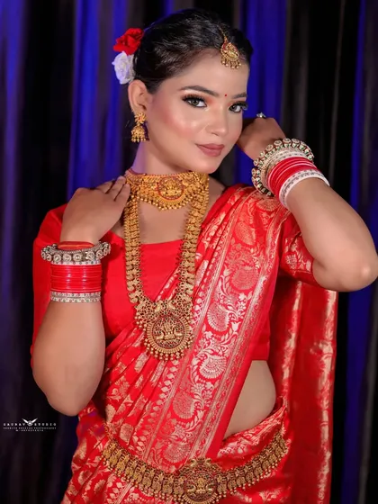 A three-quarter shot highlighting the traditional gold jewelry and red bangles.