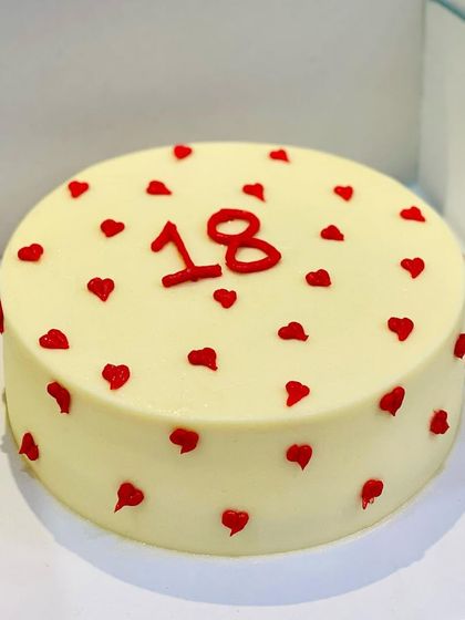 Keeping it simple for an 18th birthday. This minimalist cake with tiny red hearts is chic, sweet, and perfect for a milestone celebration.