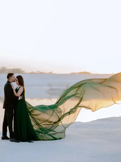 A classic kiss on the forehead, with the flowing gown catching the last rays of sunlight. This is a timeless romantic shot, made even more special by the unique location.