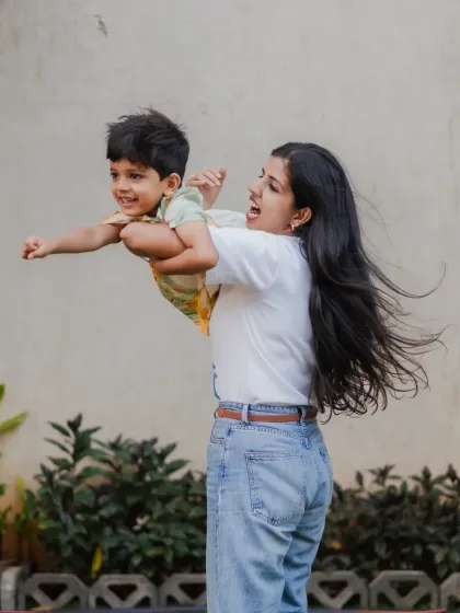 The 'superman' pose is always a favorite with kids. This candid shot from a family session captures the pure joy and excitement of being lifted up by a parent.