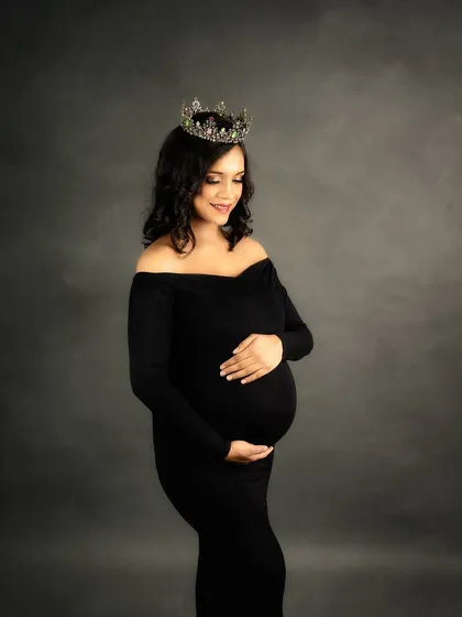 Every mother is a queen, and sometimes she needs a crown to match. This classic, elegant portrait in a black gown shows how a simple prop can add a touch of regal grace to your maternity photos.