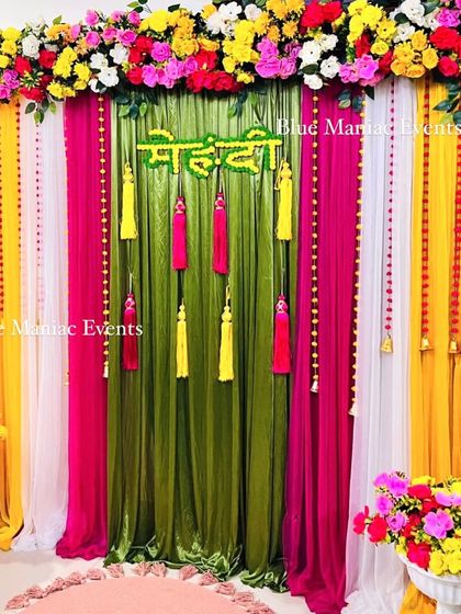 A closer view of the colorful Mehendi backdrop, highlighting the 'Mehendi' sign and the hanging tassels.