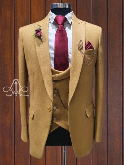 A sharp mustard yellow three-piece suit. This is a bold, confident choice for the man who isn't afraid of color. The rich fabric and impeccable tailoring make it a standout piece for any occasion.