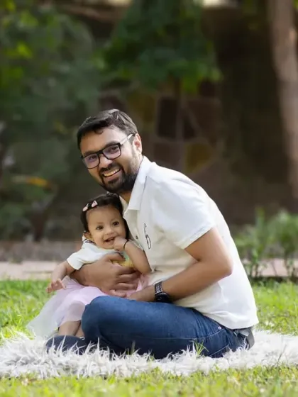 A father's gentle hold. This portrait captures the special bond between a dad and his baby girl during their outdoor family photoshoot.