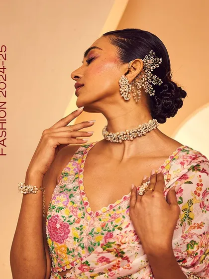 A complete festive look featuring our pearl earcuff, choker, bracelet, and ring set against a floral lehenga.