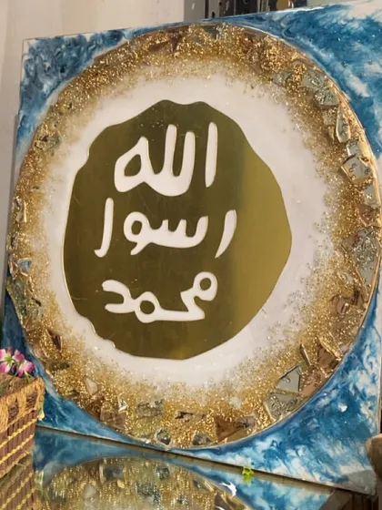 This luxury wall art features the Mohr e Nabuwat, or the Seal of Prophet Muhammad (PBUH). The design is set in gold and turquoise resin with a geode-like textured border, perfect for an exquisite living room.
