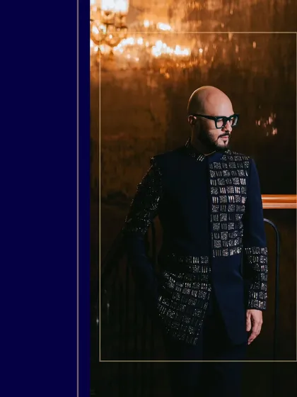 A stylish portrait of the groom in his embellished bandhgala, framed with a deep blue border for an elegant, magazine-like feel.