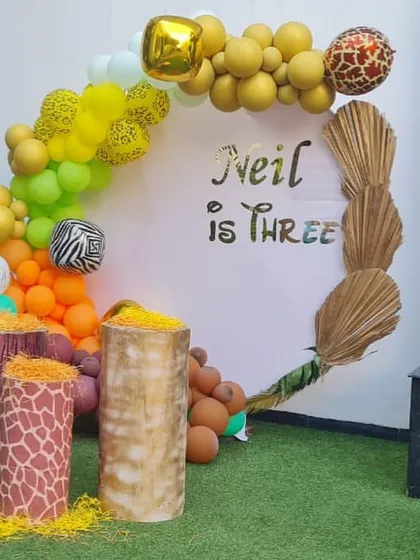 A stylish and modern jungle-themed backdrop for a third birthday party.