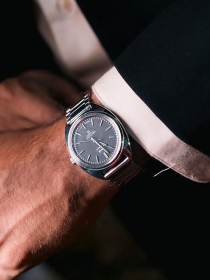 A close-up of the groom's classic timepiece, a symbol of the timeless commitment he is about to make.