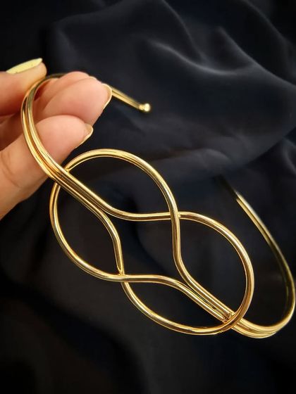 A close-up of the Layla Lotus gold Hasli statement neckpiece, showing the beautiful knot detail. It's anti-tarnish.