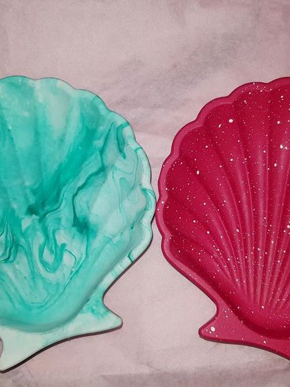 Two of our mini shell dishes, one in a green marble and the other in a solid red with white speckles.