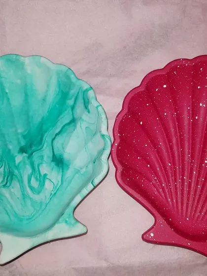 Two of our mini shell dishes, one in a green marble and the other in a solid red with white speckles.