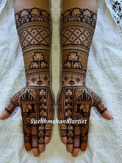 A classic bridal design with peacocks on the palms and elephants on the forearms. The use of lotus motifs and jaali patterns fills the hands beautifully.