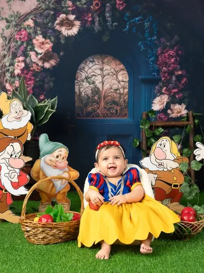 A happy smile from Snow White as she sits with a basket of apples.
