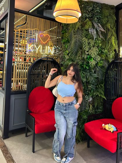 Posing in the iconic birdcage chairs at Kylin. This highlights a unique and Instagrammable feature of the restaurant.