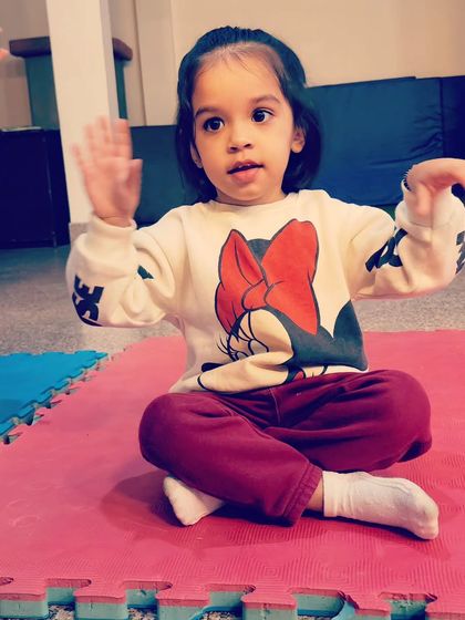 This little one is all ears and ready for the next instruction. We teach toddlers to follow rhythms and cues in a fun, interactive way.