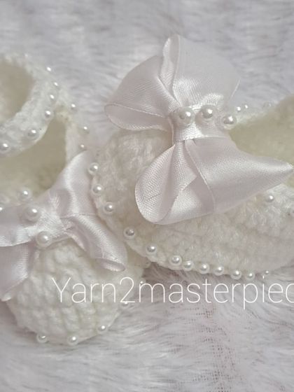 A close-up view of the satin bow booties, showing how the pearls are carefully stitched along the strap for a touch of sparkle.