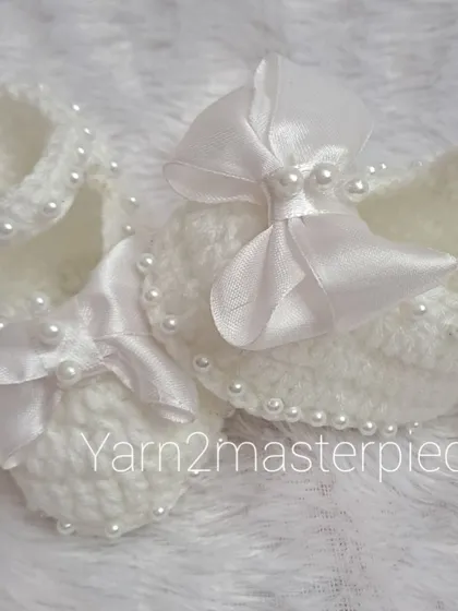 A close-up view of the satin bow booties, showing how the pearls are carefully stitched along the strap for a touch of sparkle.