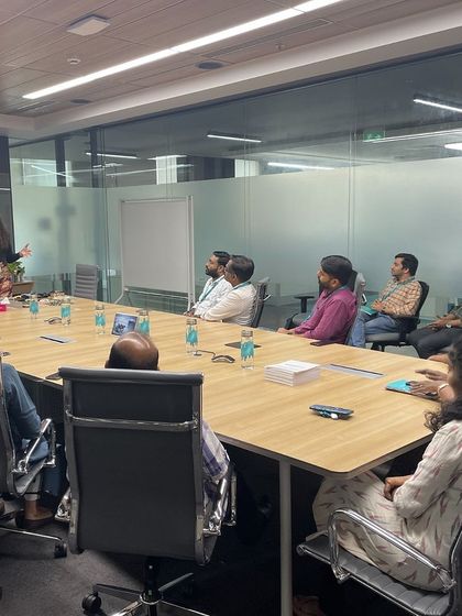 Addressing an attentive audience in a boardroom setting. My training sessions are tailored to the specific environment and needs of the client, whether it's a large hall or an intimate meeting room.