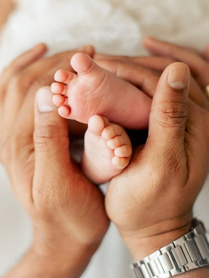 A father's hands cradling his baby's tiny feet. This is a timeless and symbolic shot that every parent cherishes.