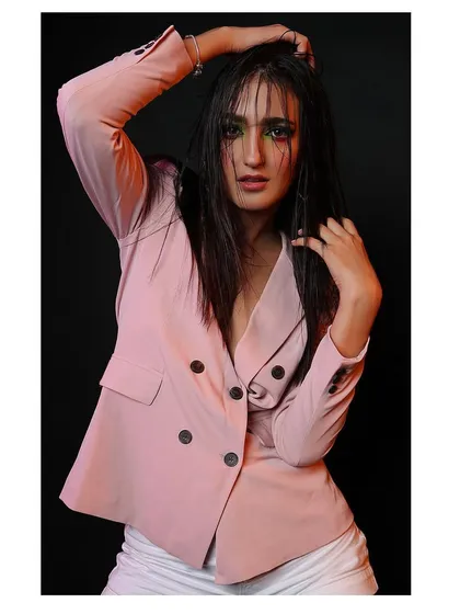 A full-body shot from the same creative beauty session, highlighting the contrast between the sharp blazer and the edgy makeup.