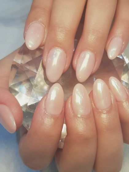 A beautiful baby pink polish gets a glamorous upgrade with a touch of chrome powder. This gives the nails a pearlescent, glazed finish that catches the light beautifully.