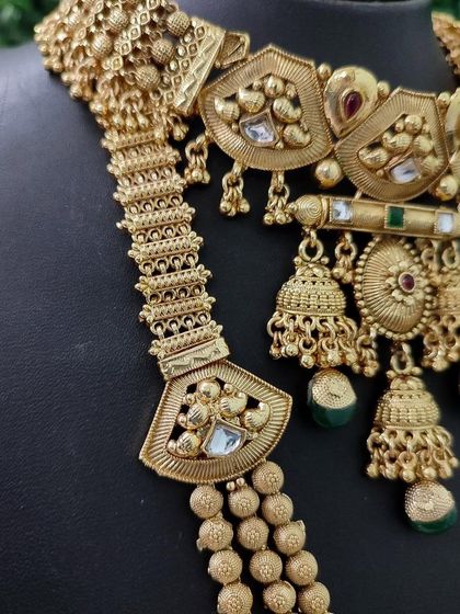 A close-up of the textured gold finish and the detailed pendants on this unique temple-inspired bridal set.