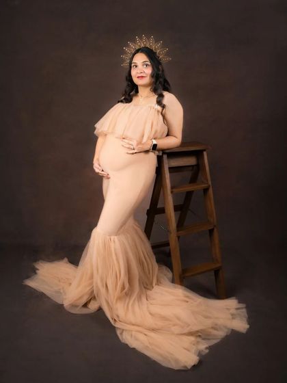 A slightly different angle of the standing pose with the wooden ladder. This full-length view highlights the beautiful mermaid-style gown and the intricate details of the boho-chic studio setup.