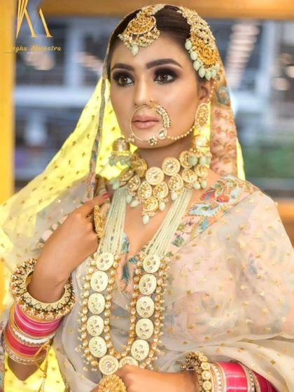 A stunning off-white jewellery set with coin-like details, paired with a matching lehenga. This is a unique and royal look for a bride who wants to stand out.