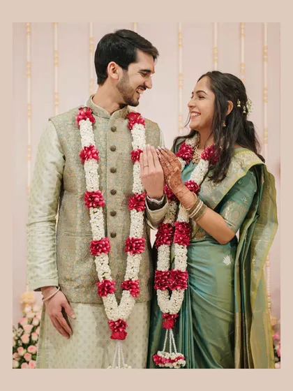 A sweet, interactive moment post-ceremony, where the couple's happy expressions and beautiful garlands tell a story of love and commitment.