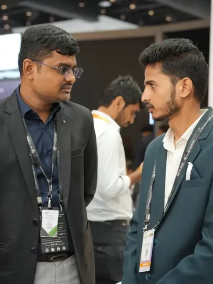 Professionals engage in a discussion at an exhibitor's booth. We provide the space for brands to connect directly with a curated audience of potential buyers and partners.