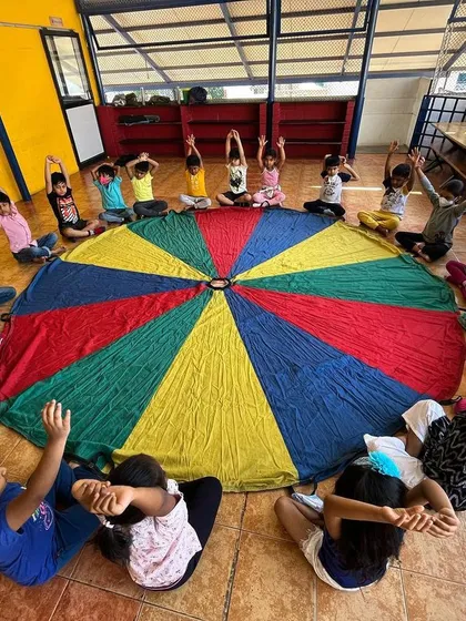 Using the giant parachute for a group stretch is a visually exciting way to cool down after a session. This activity promotes coordination and teamwork as everyone has to move together.