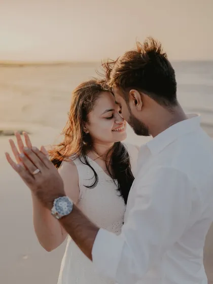 An intimate close-up of the couple dancing on the beach. The focus on their hands and happy expressions captures the romance of the moment.