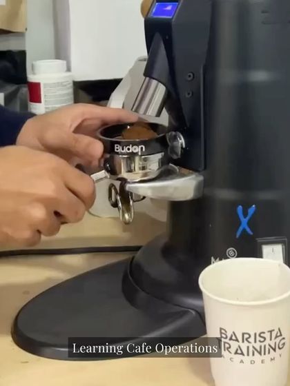 A student practices grinding beans for an espresso shot. Our flagship program provides extensive hands-on time with professional-grade equipment to build muscle memory and confidence.