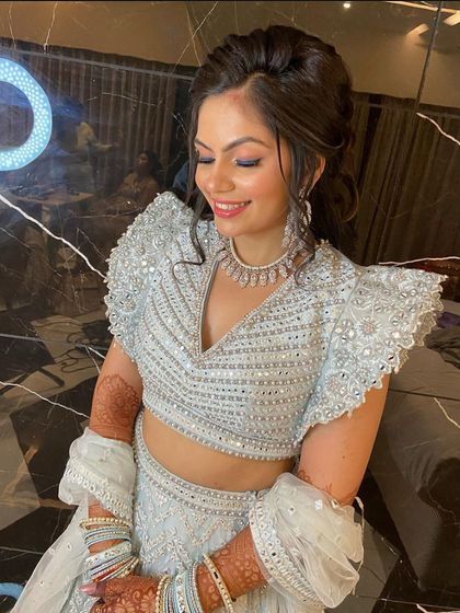 A close-up of the smiling client in our powder blue lehenga. The intricate mirror work and modern blouse cut make it a popular choice for receptions and engagements.